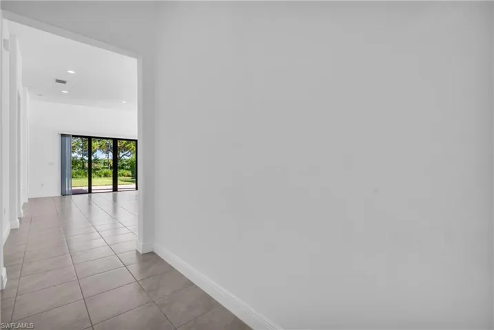 Corridor with light tile patterned flooring