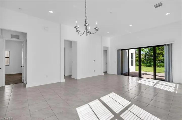 Unfurnished room featuring a chandelier and light tile patterned floors