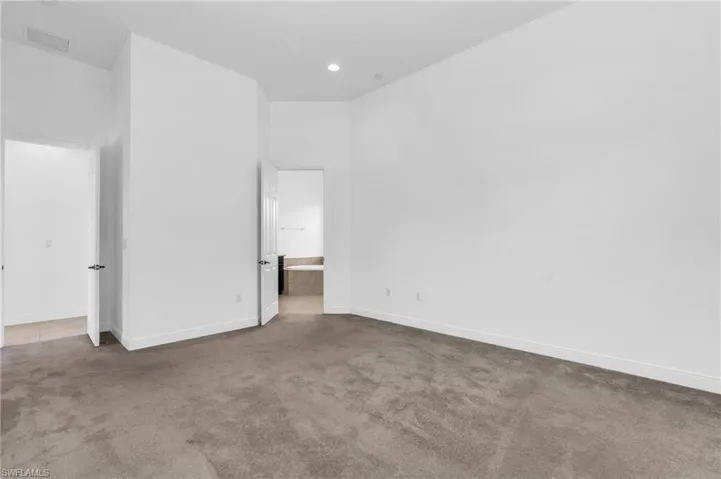 Unfurnished bedroom featuring connected bathroom and carpet floors