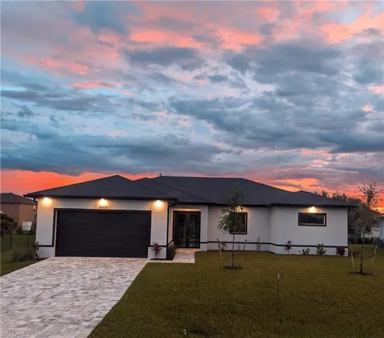 Prairie-style home featuring a garage and a yard- Garage door just painted