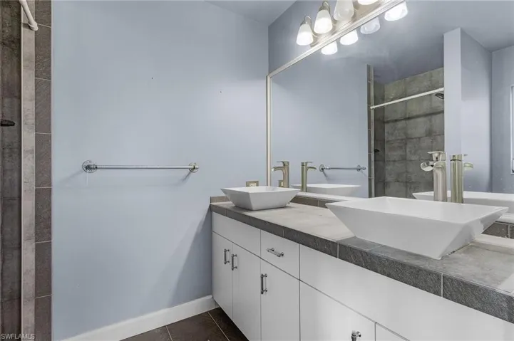Bathroom with tile patterned flooring and dual bowl vanity