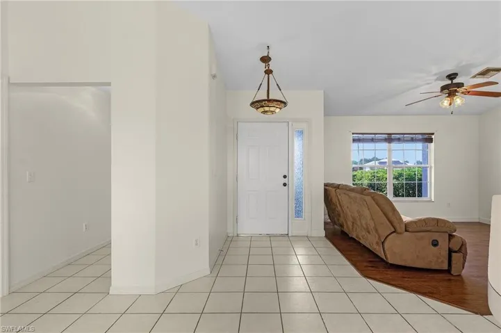 Entryway with light tile patterned floors and ceiling fan