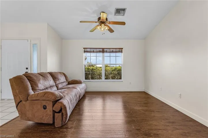 Living room with hardwood / wood-style floors and ceiling fan
