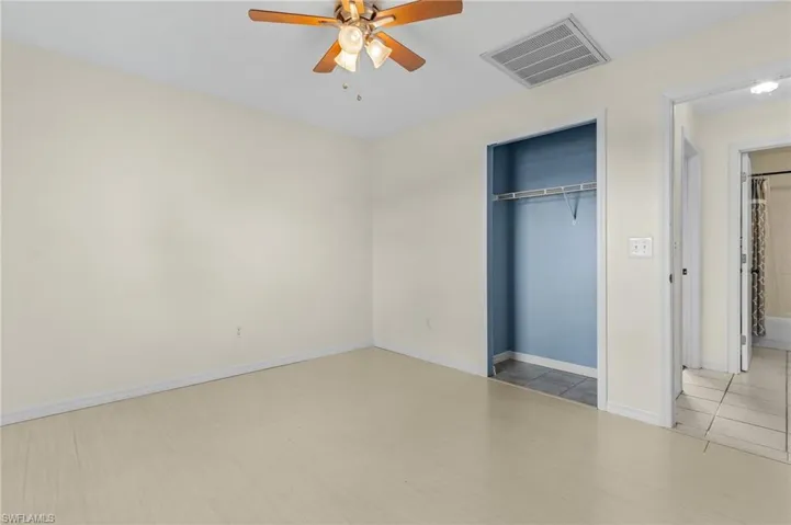 Unfurnished bedroom featuring light tile patterned floors, a closet, and ceiling fan
