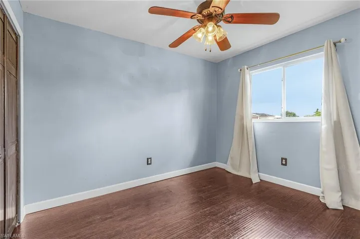 Unfurnished room with ceiling fan and hardwood / wood-style floors