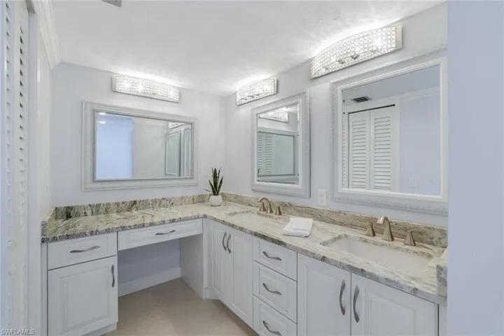 Bathroom with dual sinks and make-up sitting area.