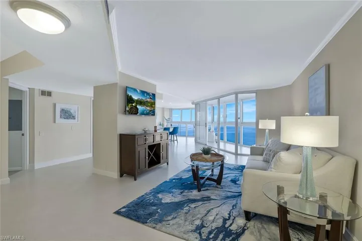 Living room with crown molding, floor to ceiling windows.