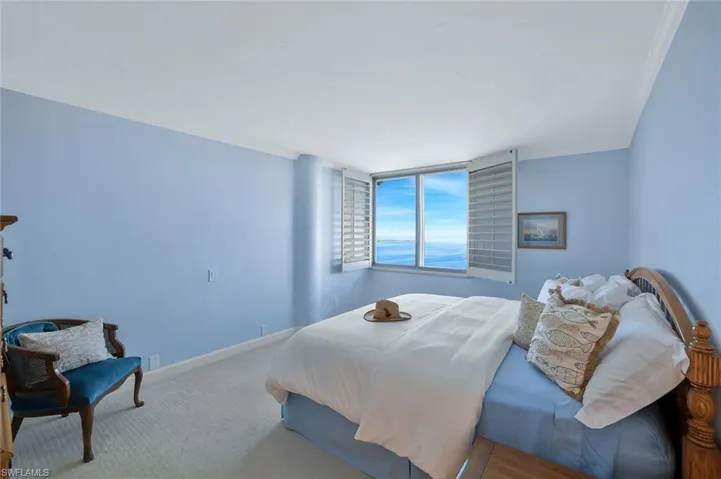 Large master bedroom features crown molding, neutral carpet and beautiful views.