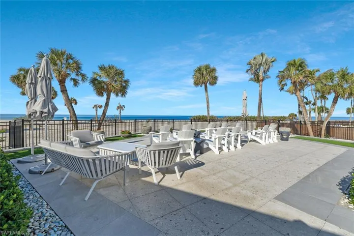View of patio featuring a water view, fire pit and outdoor lounge area