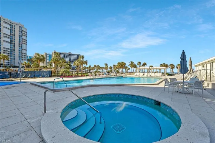 View of pool featuring a hot tub and a patio