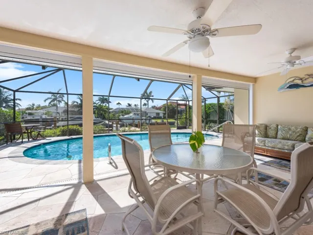 Outdoor pool with a patio area, a lanai, and ceiling fan