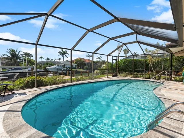 Outdoor pool with glass enclosure and a patio