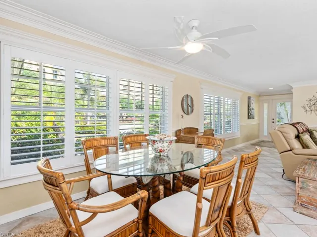 Dining space with a ceiling fan, light tile patterned floors, baseboards, and ornamental molding