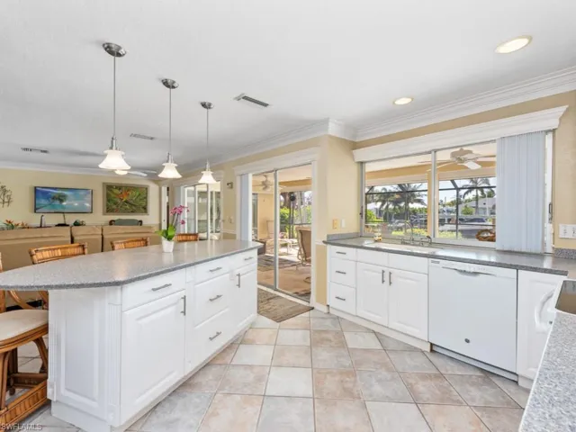Kitchen with ornamental molding, visible vents, a center island, a sink, and white dishwasher