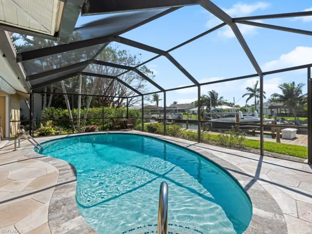 Outdoor pool featuring a patio area and glass enclosure