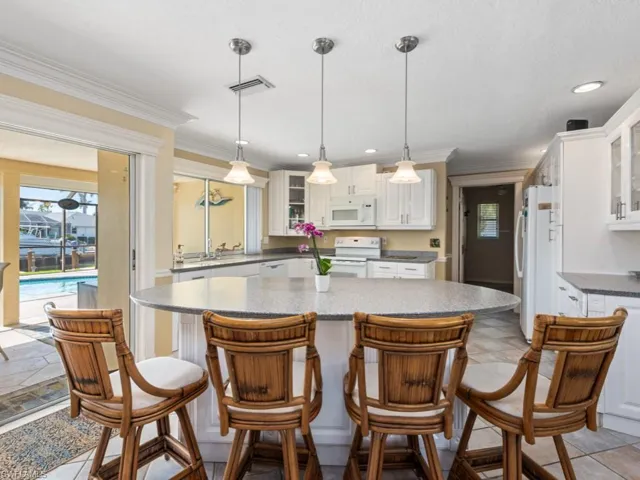 Kitchen with white appliances, visible vents, white cabinetry, and crown molding
