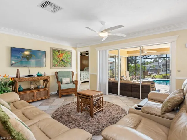 Living area with a sunroom, crown molding, ceiling fan, and visible vents