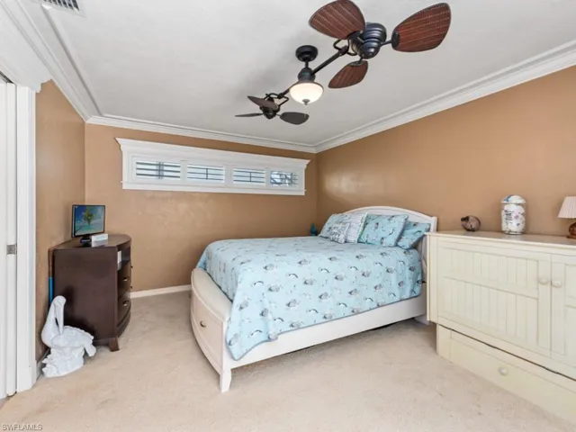 Bedroom featuring crown molding, baseboards, a ceiling fan, and carpet