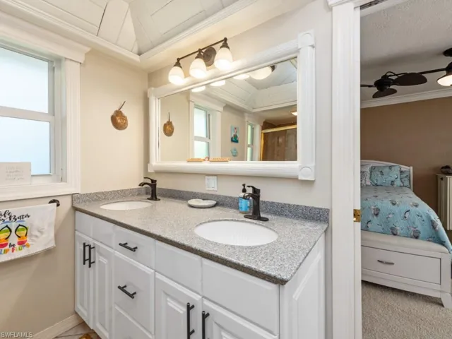 Ensuite bathroom with ornamental molding, a sink, and connected bathroom