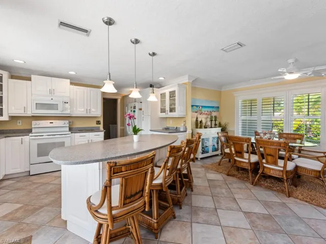 Kitchen featuring ornamental molding, white appliances, glass insert cabinets, a kitchen island, and visible vents