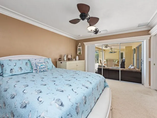 Bedroom featuring crown molding, visible vents, ceiling fan, and carpet