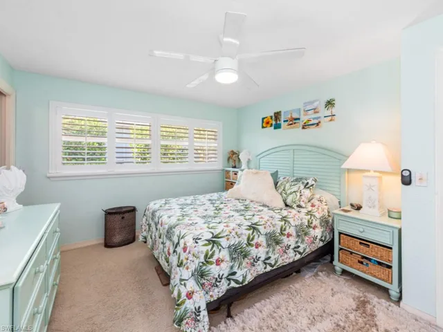 Bedroom with baseboards, ceiling fan, and light carpet