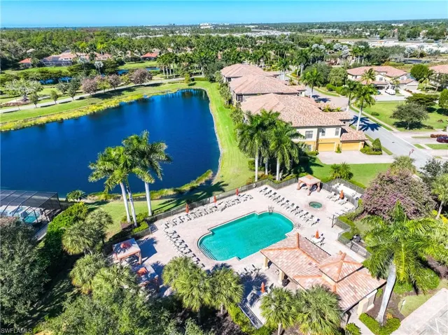 Aerial perspective of suburban area with a large body of water and a pool area