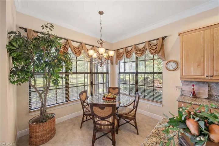 Dining space featuring crown molding, a chandelier, healthy amount of natural light, and light tile patterned floors