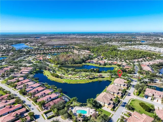 Aerial view of property and surrounding area featuring a nearby body of water and nearby suburban area