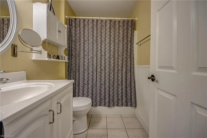 Guest bathroom with light color tile flooring, oversized vanity, plenty of cabinet space, and shower/tub combination.