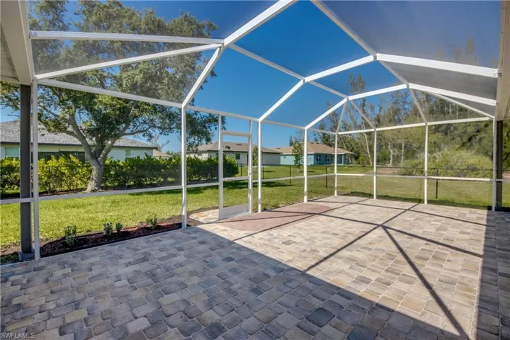Tremendously sized, screened-in, brick paver patio with gorgeous view of fenced-in back yard.