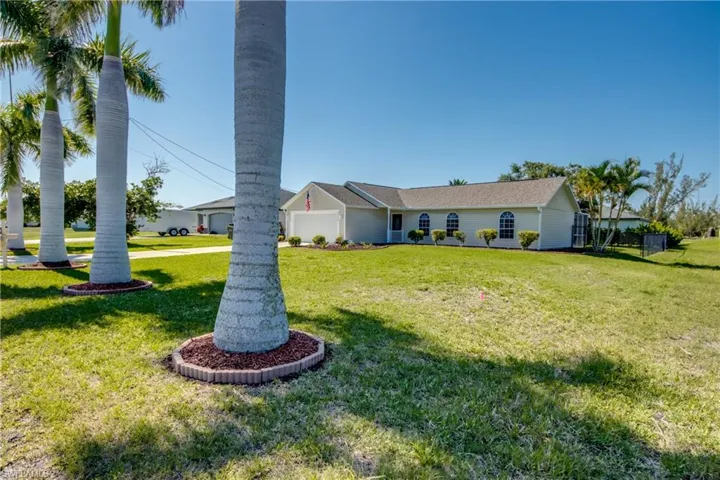 View of front yard taking into account the four lush Royal Palms lining the roadway.
