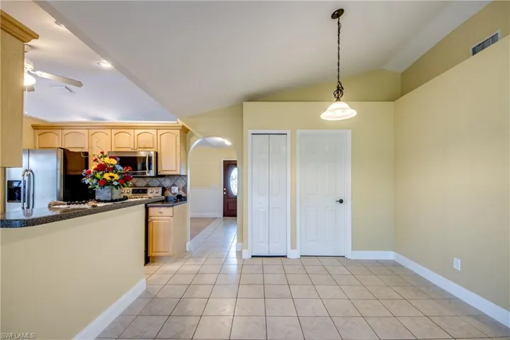 Welcoming supplemental dining area featuring light tile flooring and a cozy chandelier.