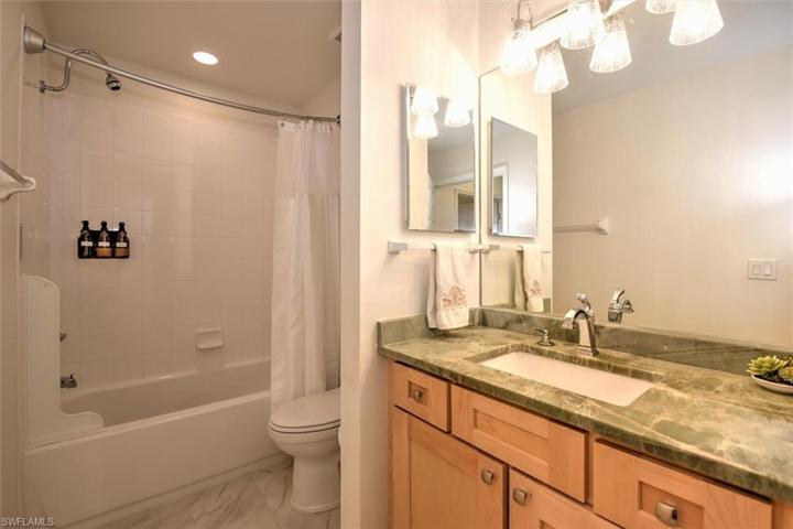 Main bathroom adjacent to guest bedroom with updated maple cabinetry, undermount sink, plumbing fixtures & exquisite quartz countertop!