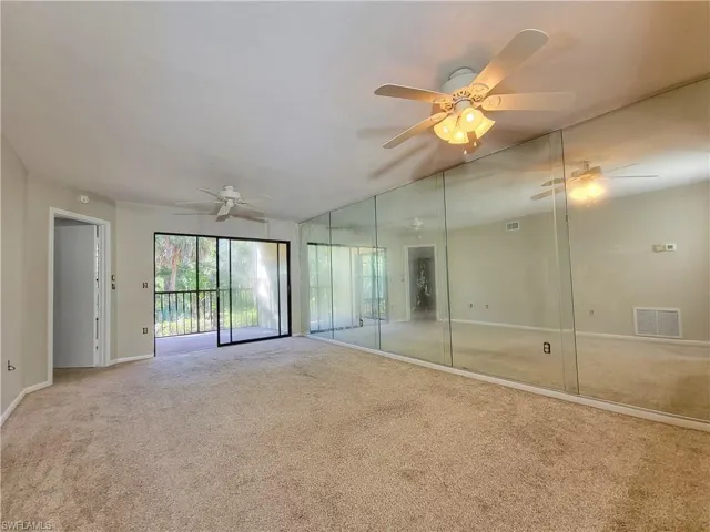 Carpeted empty room featuring ceiling fan