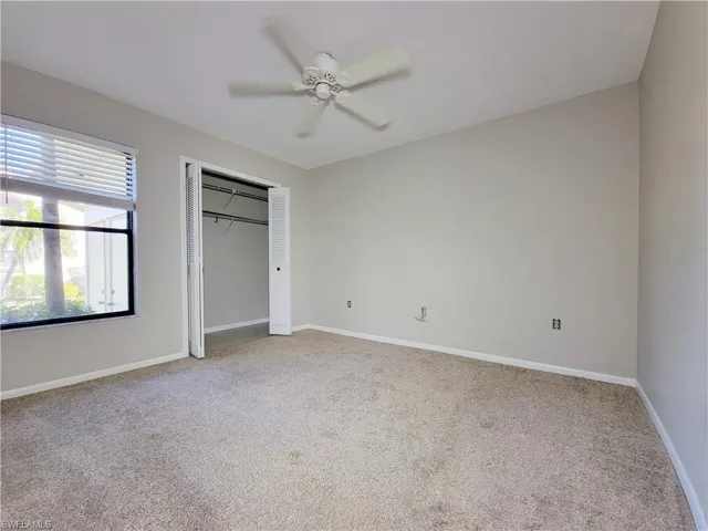 Unfurnished bedroom with ceiling fan, a closet, and carpet
