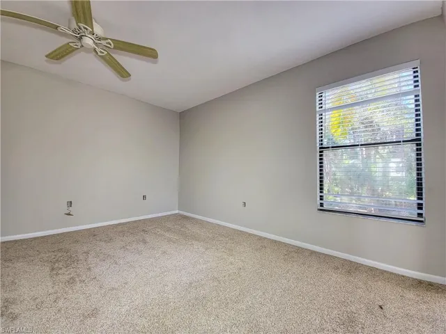 Carpeted spare room with ceiling fan