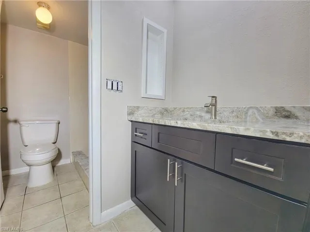 Bathroom with tile patterned flooring, vanity, and toilet