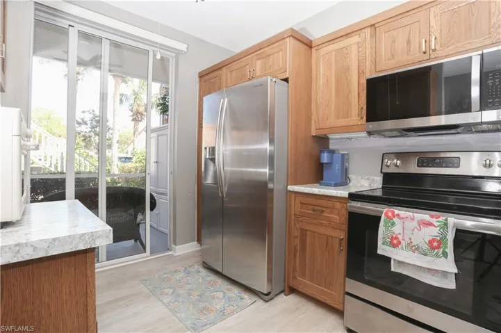 Kitchen with stainless steel appliances, light countertops, light wood-style floors, and wood finish cabinets