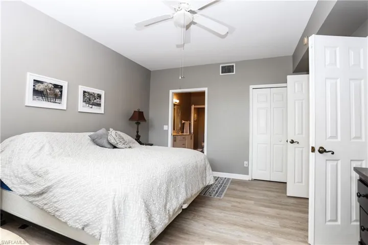 Bedroom featuring light wood-type flooring, ensuite bath, and ceiling fan