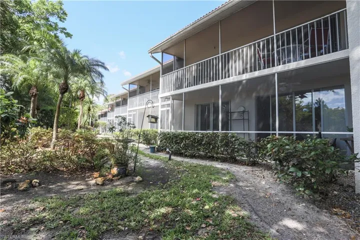 View of side of property featuring a sunroom, a balcony, and stucco siding