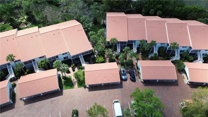 Drone / aerial view of apartment complex / building and a tree filled landscape
