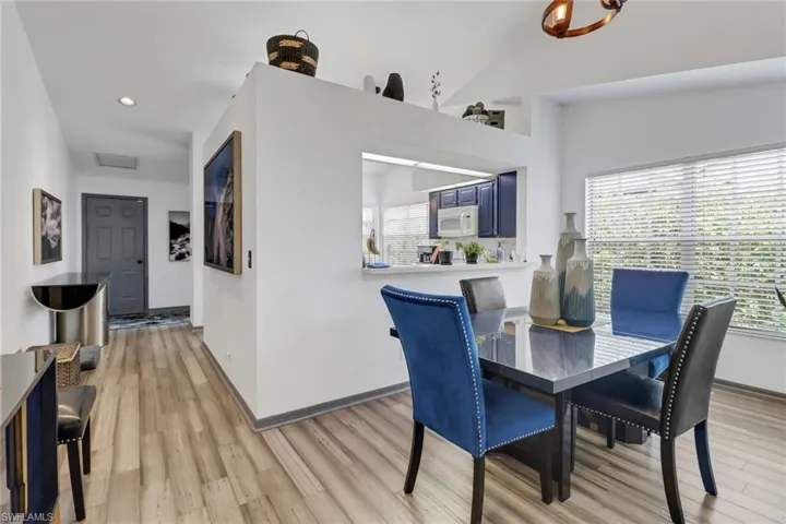Dining room with light wood-type flooring and vaulted ceiling