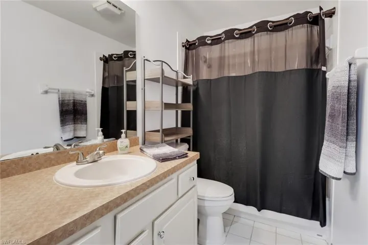 Bathroom featuring vanity, tile patterned floors, and toilet