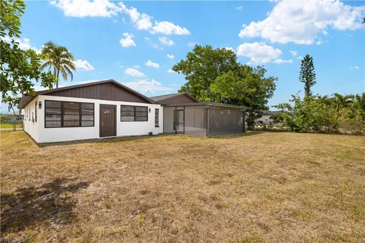 Back of house featuring a sunroom and a yard