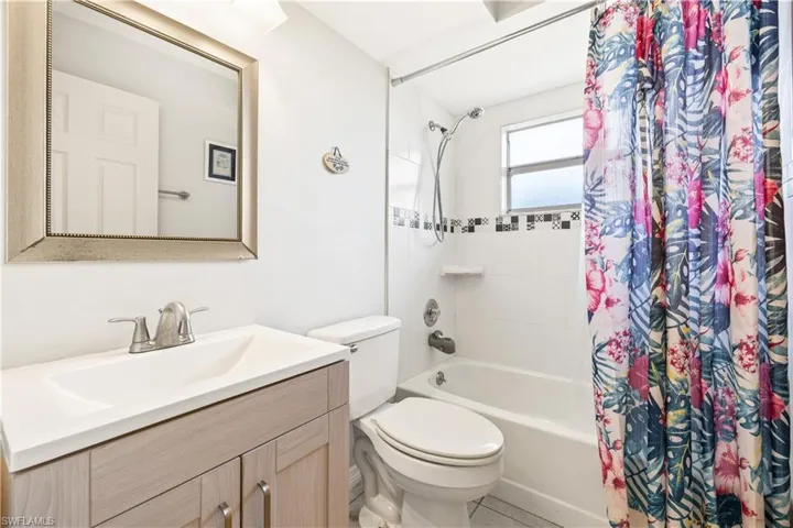Bathroom with vanity, toilet, and shower / tub combo with curtain