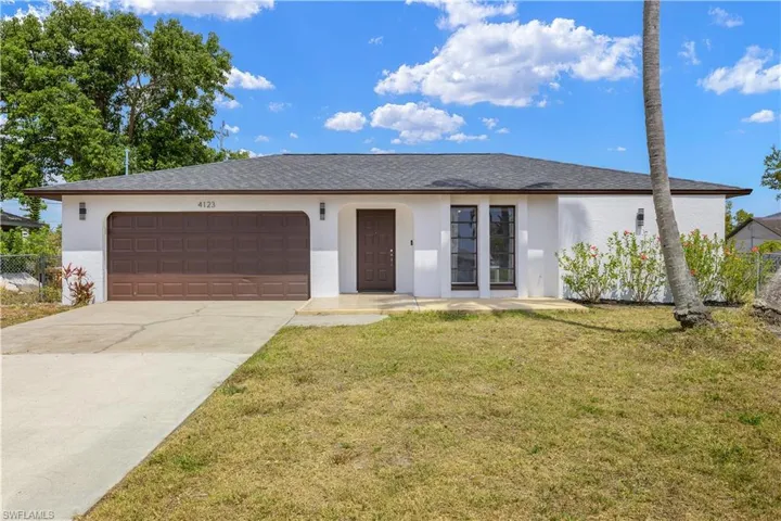 Ranch-style home with a garage, stucco siding, concrete driveway, and a front yard