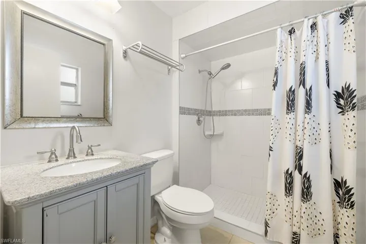 Bathroom with vanity, toilet, and tiled shower