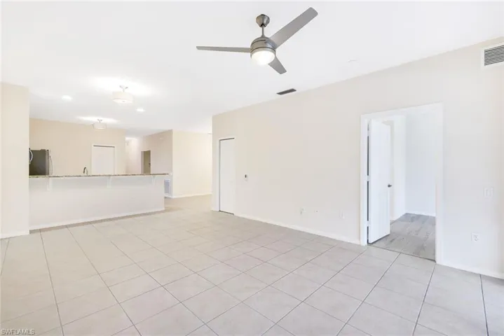 Unfurnished living room with ceiling fan and light tile patterned floors