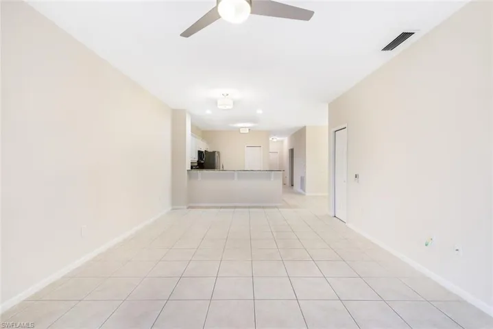 Unfurnished living room featuring ceiling fan and light tile patterned floors